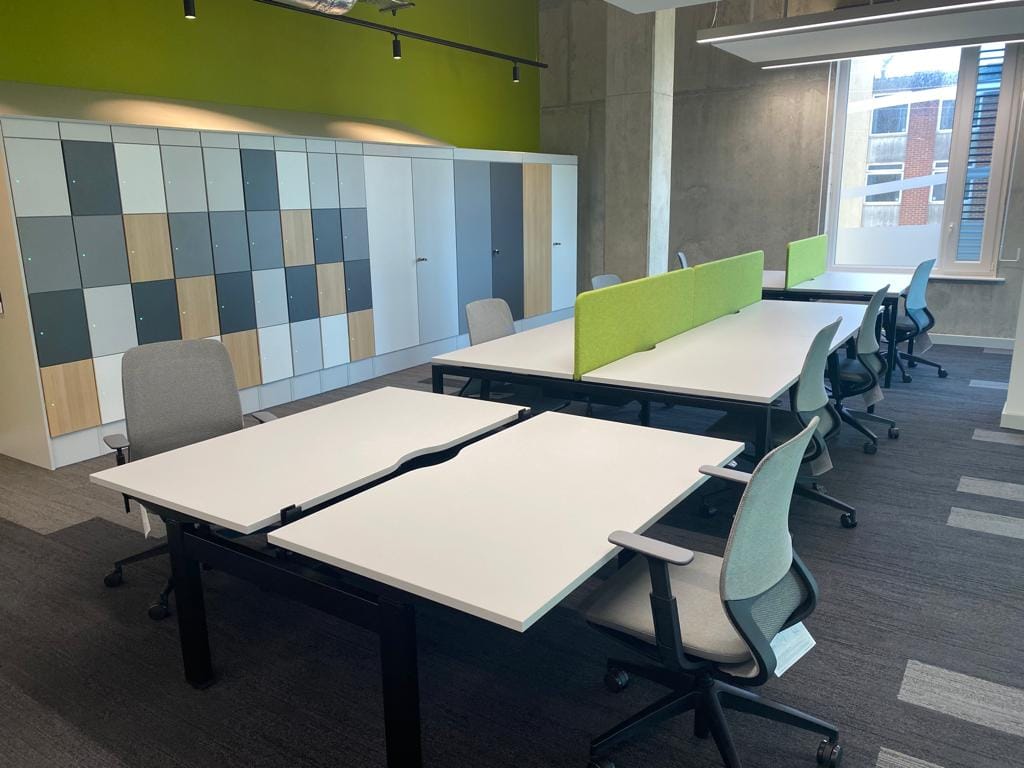 green partition with a white desk in a office building